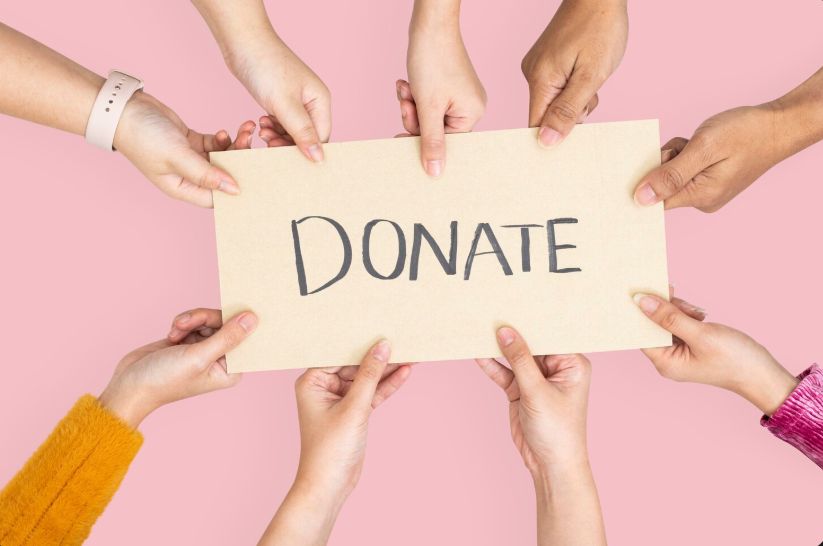 Hands holding a DONATE sign to support free care for those in need